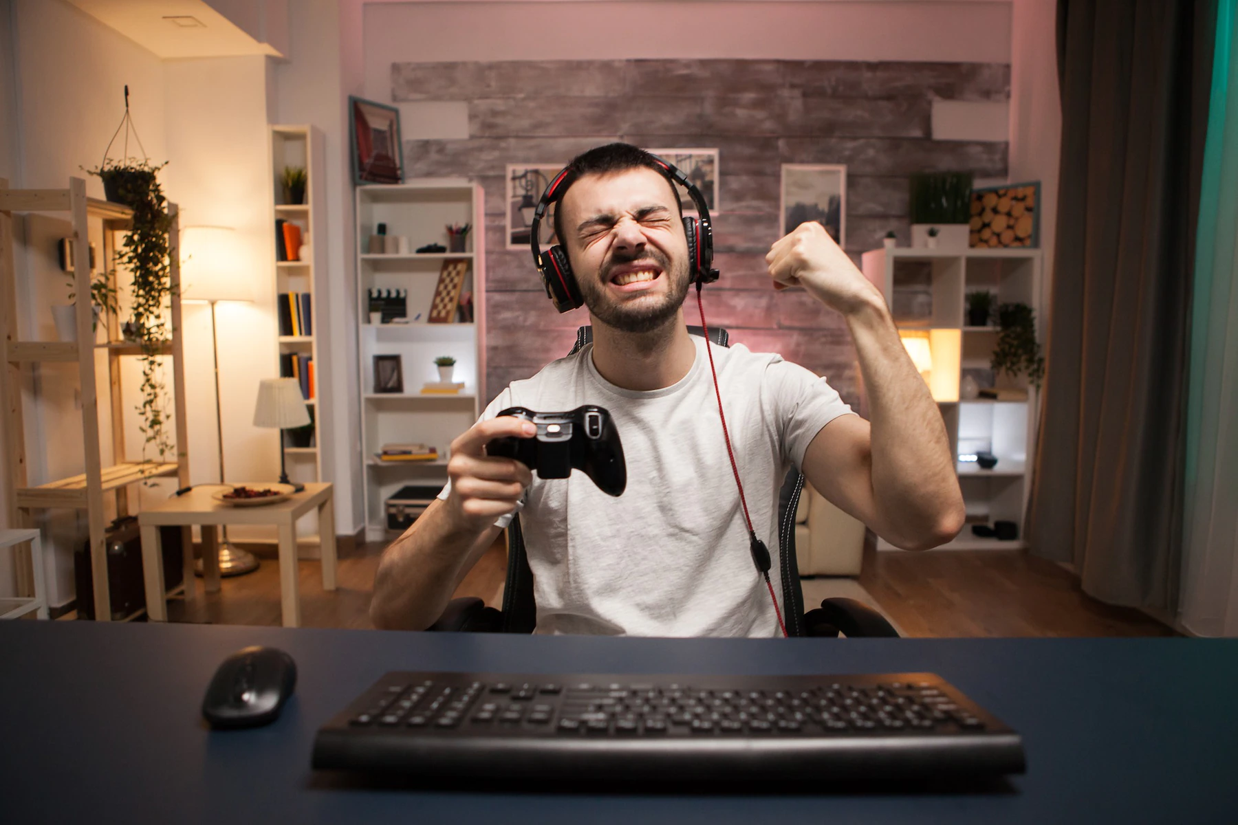 pov of happy young man celebrating his victory on online shooter game using wireless controller 482257 17356