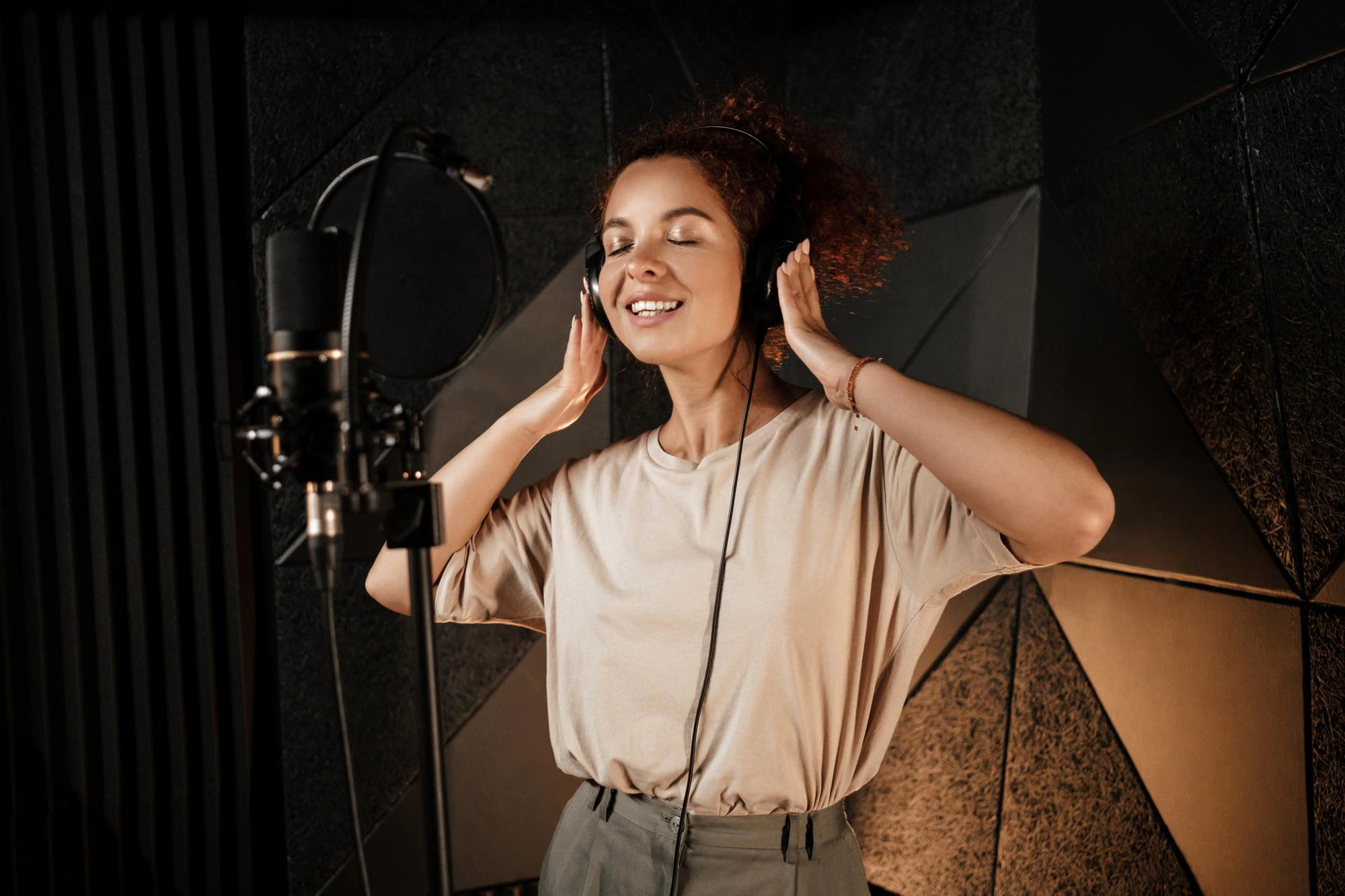 beautiful smiling singer girl in headphones dreamily recording new song in professional studio 574295 1750