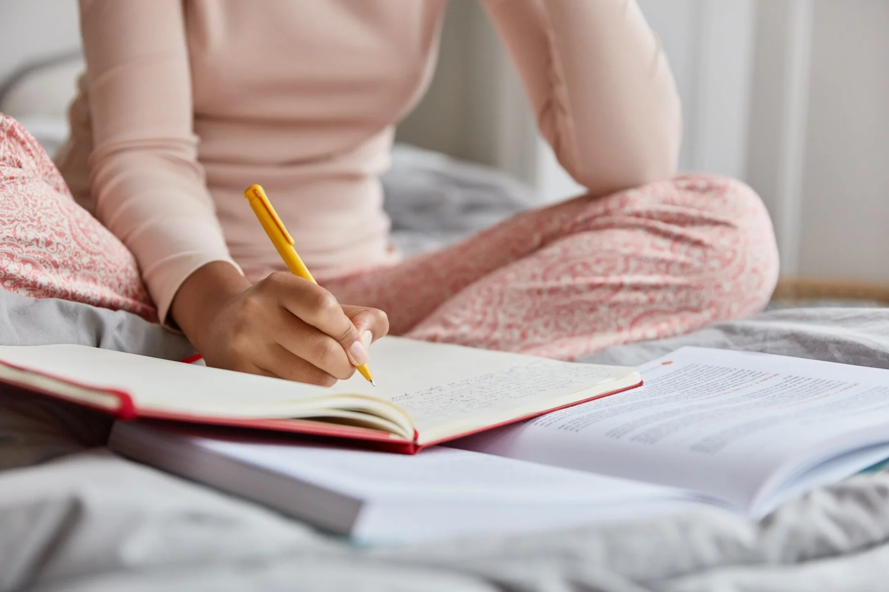 cropped image unrecognizable woman nightclothes writes down information notepad rewrites topic from textbook poses bed alone has nice handwriting close up shot focus writing 273609 29021