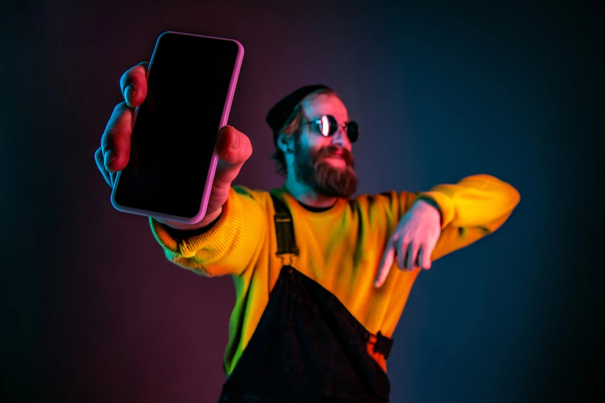 showing phone s blank screen caucasian man s portrait gradient studio background neon light beautiful male model with hipster style concept human emotions facial expression sales ad 155003 30714