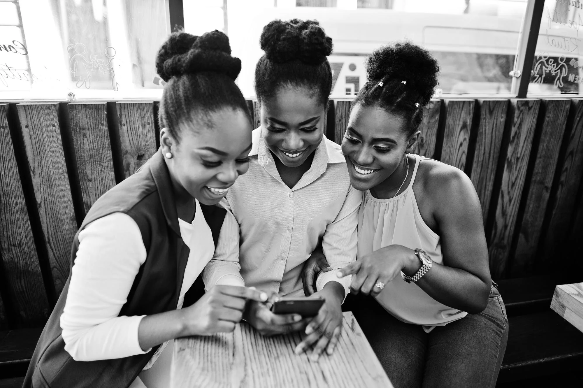 three african american girls sitting table caffe looking mobile phone 627829 14350