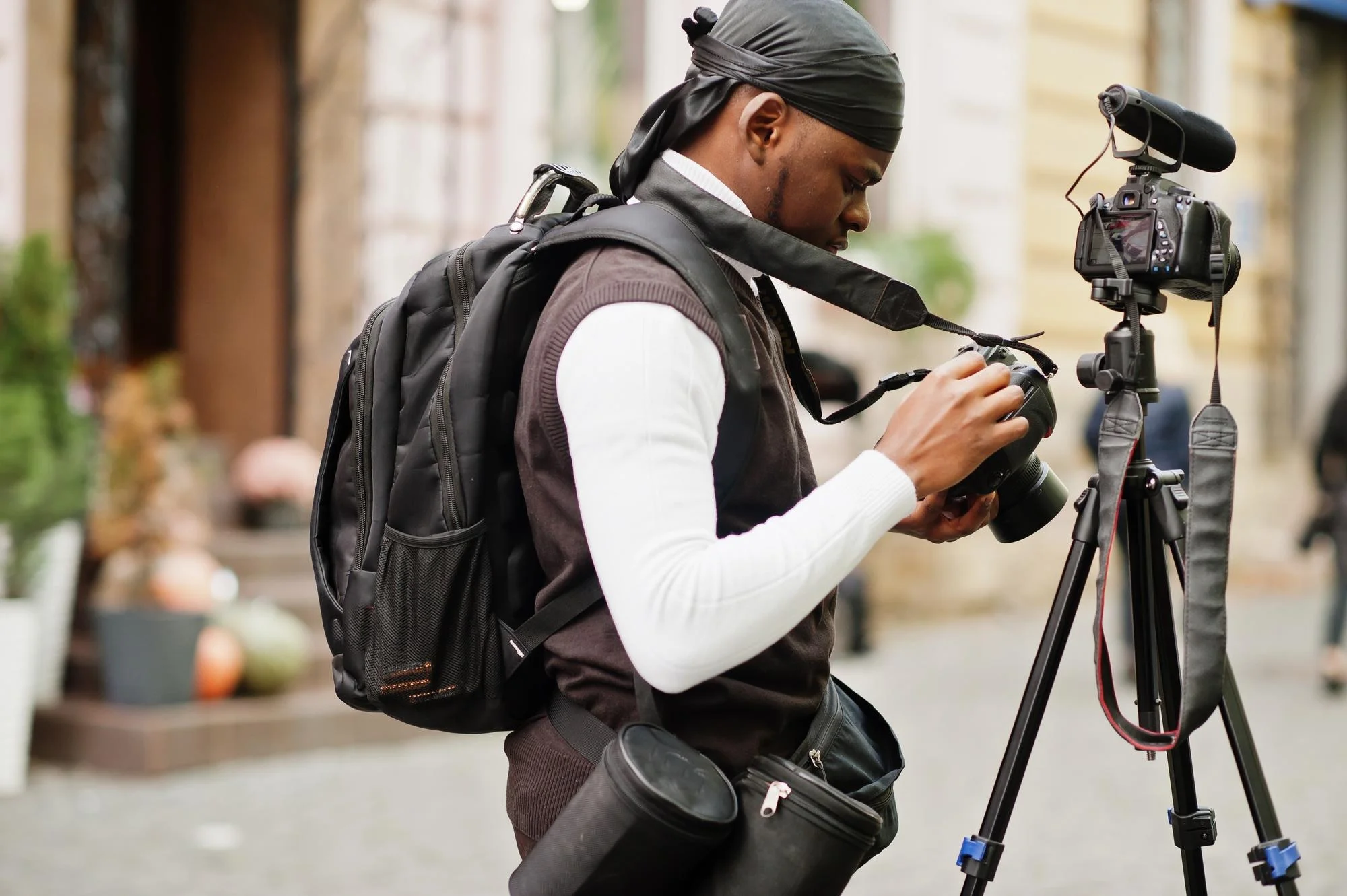 young professional african american videographer holding professional camera with tripod pro equipment afro cameraman wearing black duraq making videos 627829 4378