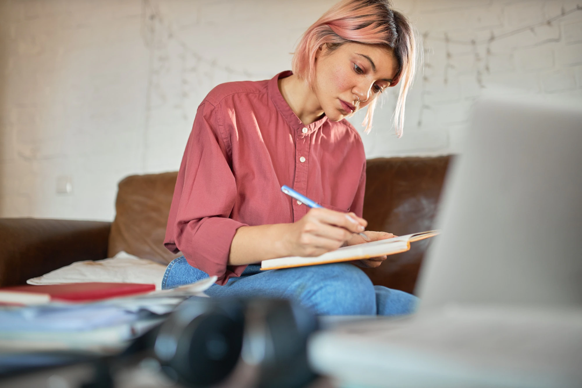 concentrated young woman copywriter with pink hair working from home making notes copybook 343059 3791
