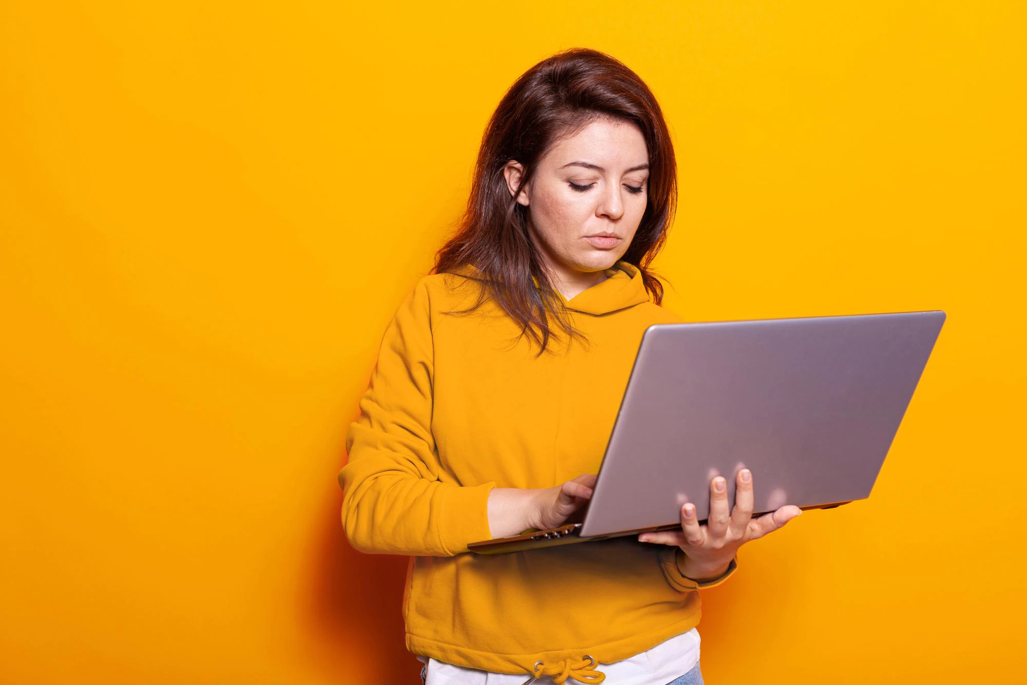 modern person holding laptop use technology camera studio portrait young woman looking digital device screen working online while standing isolated background 482257 28871